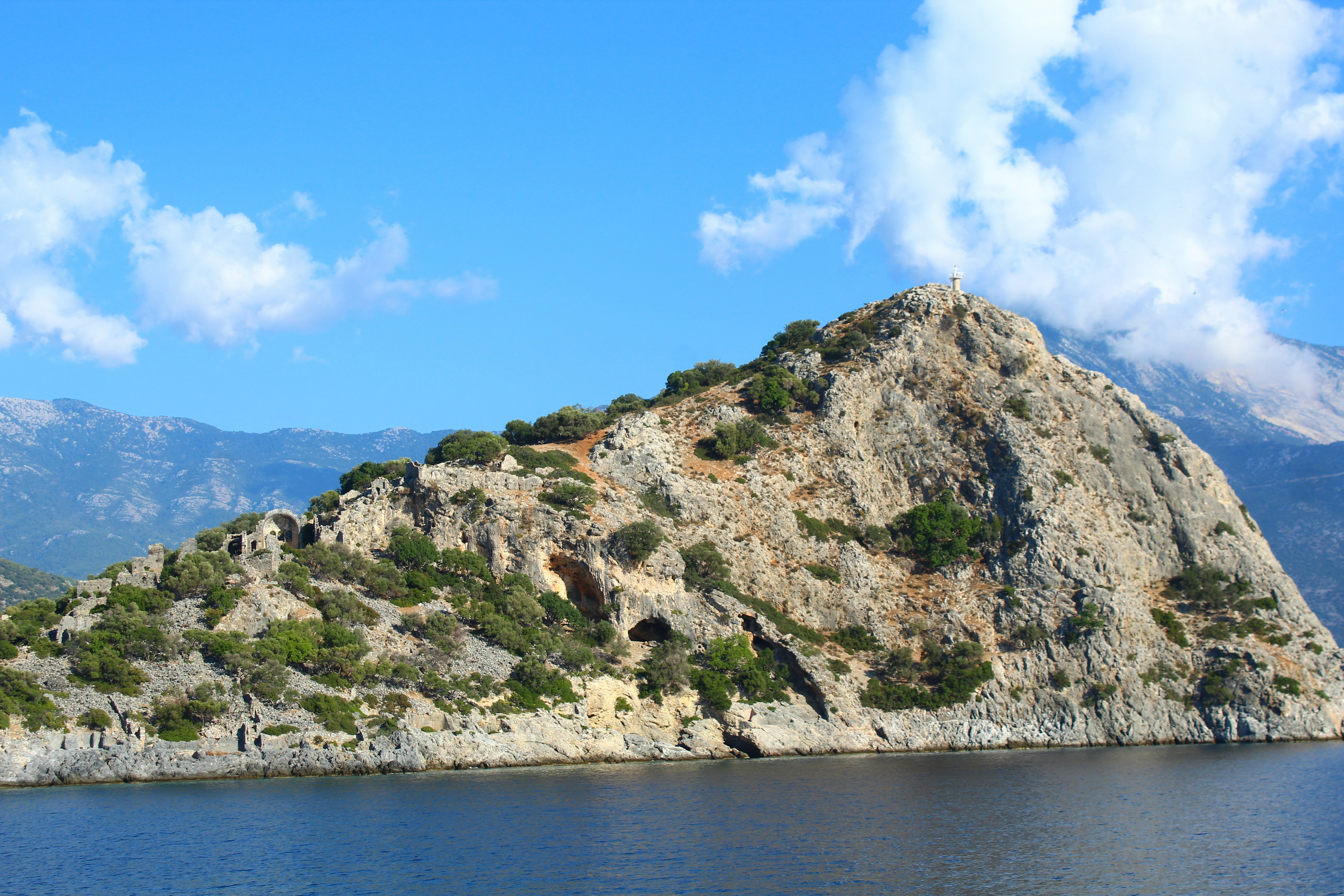 a rocky cliff next to a body of water