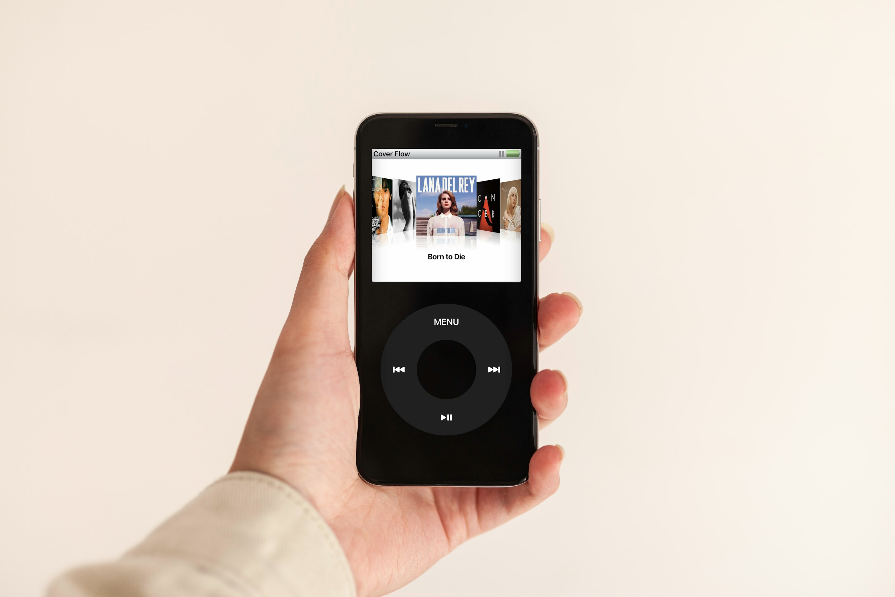 Mão esquerda a segurar um iPod com o álbum "Born to Die", de Lana Del Rey, no centro do ecrã.