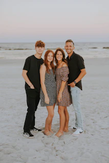 a group of people posing for a photo on a beach