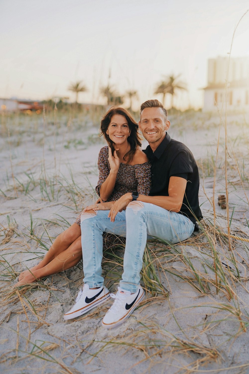 a man and woman sitting on a beach