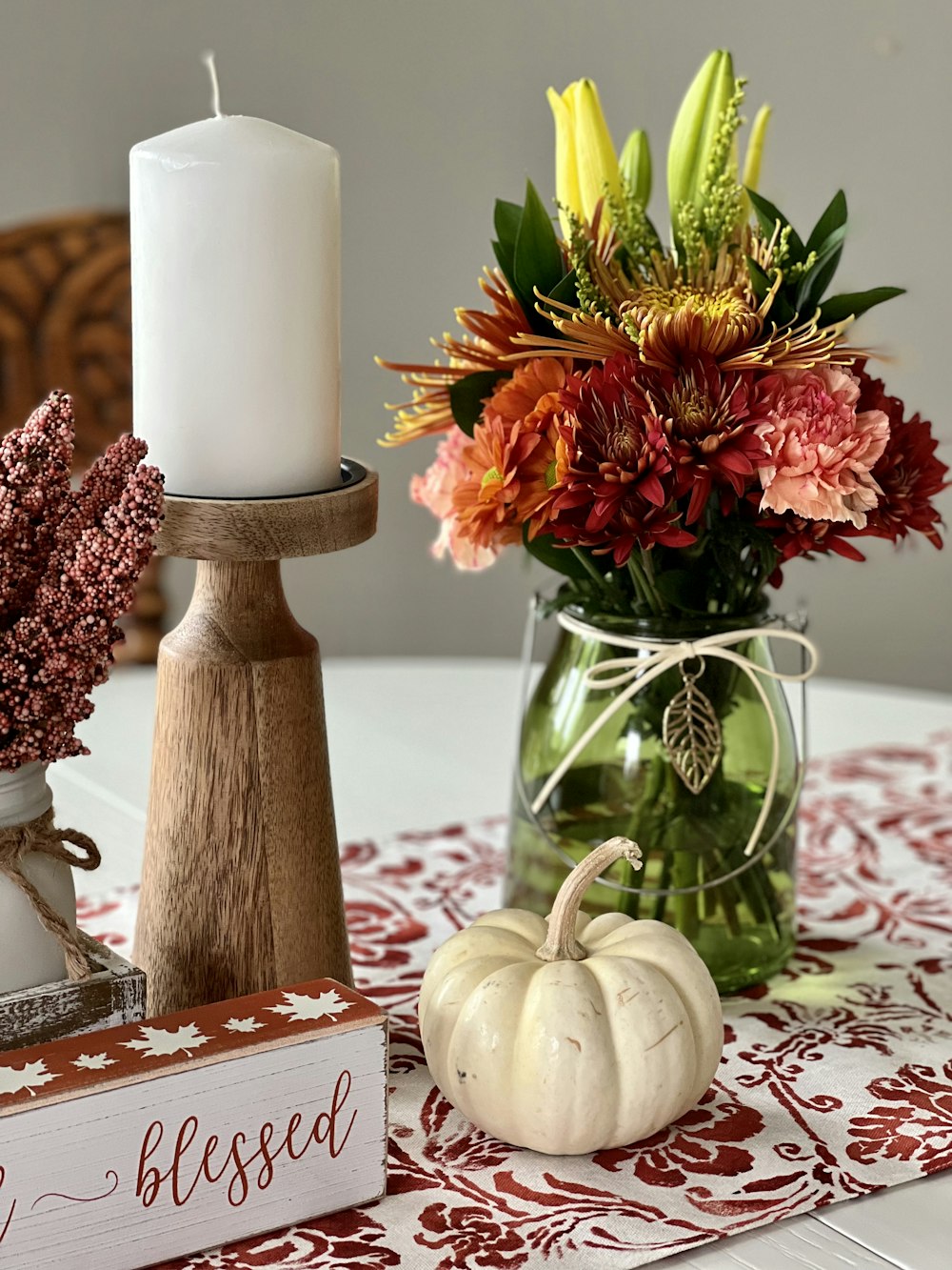 a vase with flowers and a candle