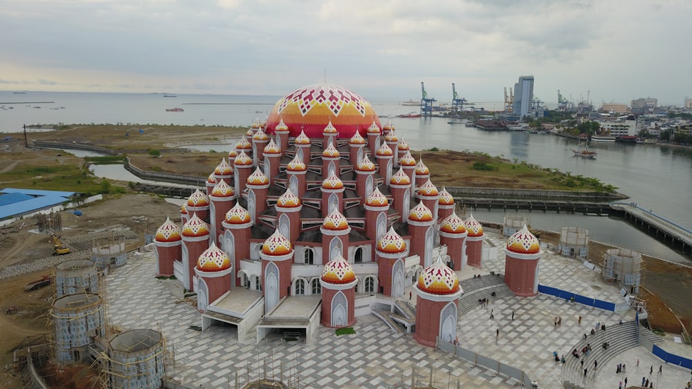 a building with a large roof and a body of water in the background