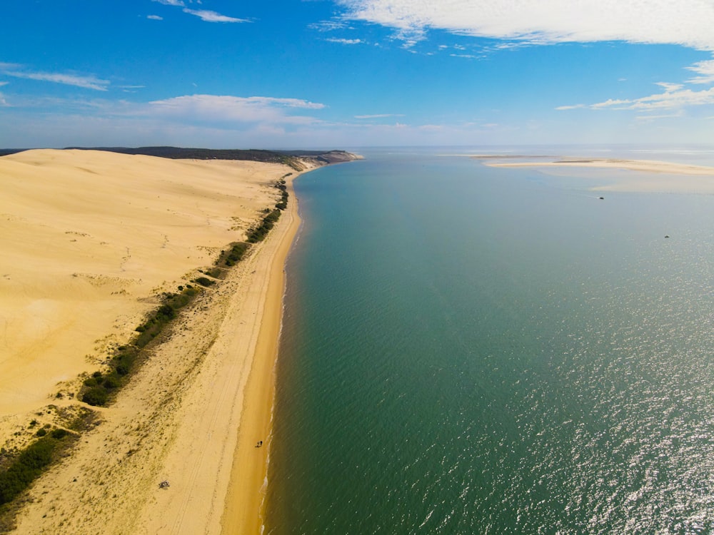 a sandy beach with a body of water in the background