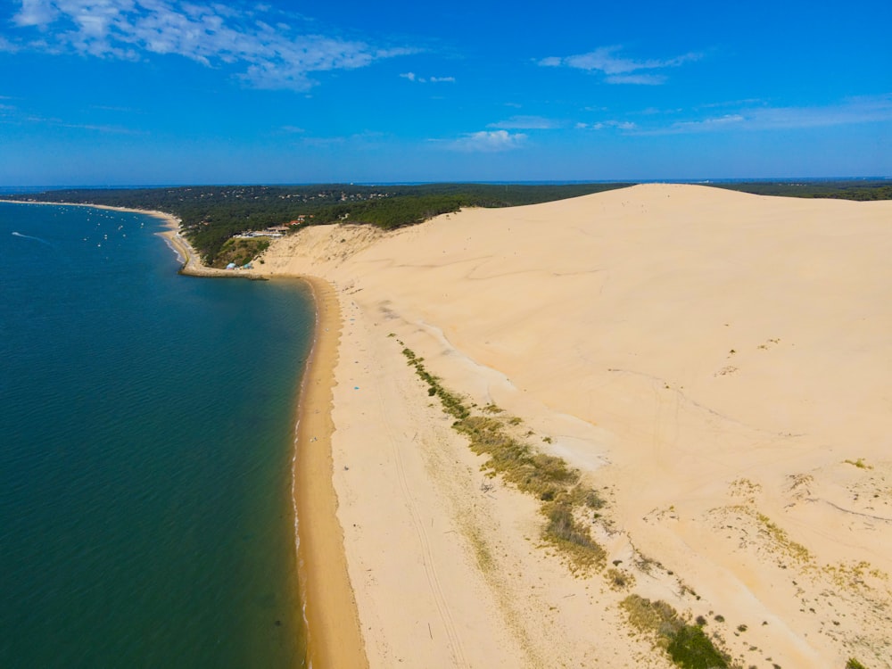 a sandy beach with a body of water in the background