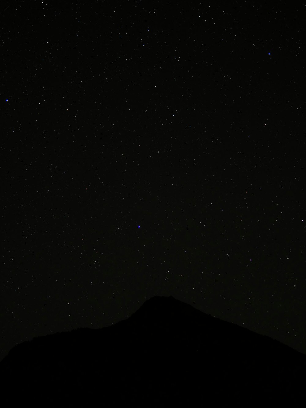 a mountain under a starry sky