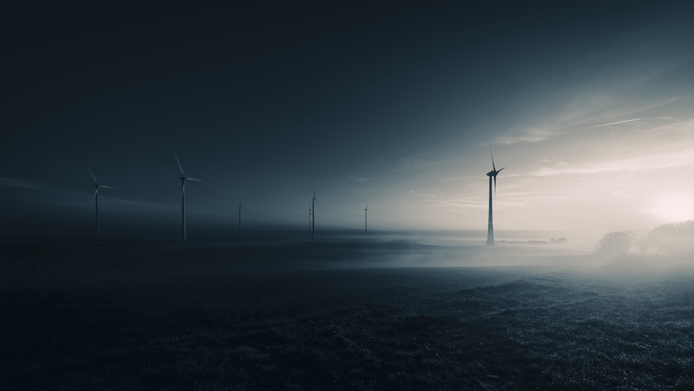 a group of wind turbines in a field at night