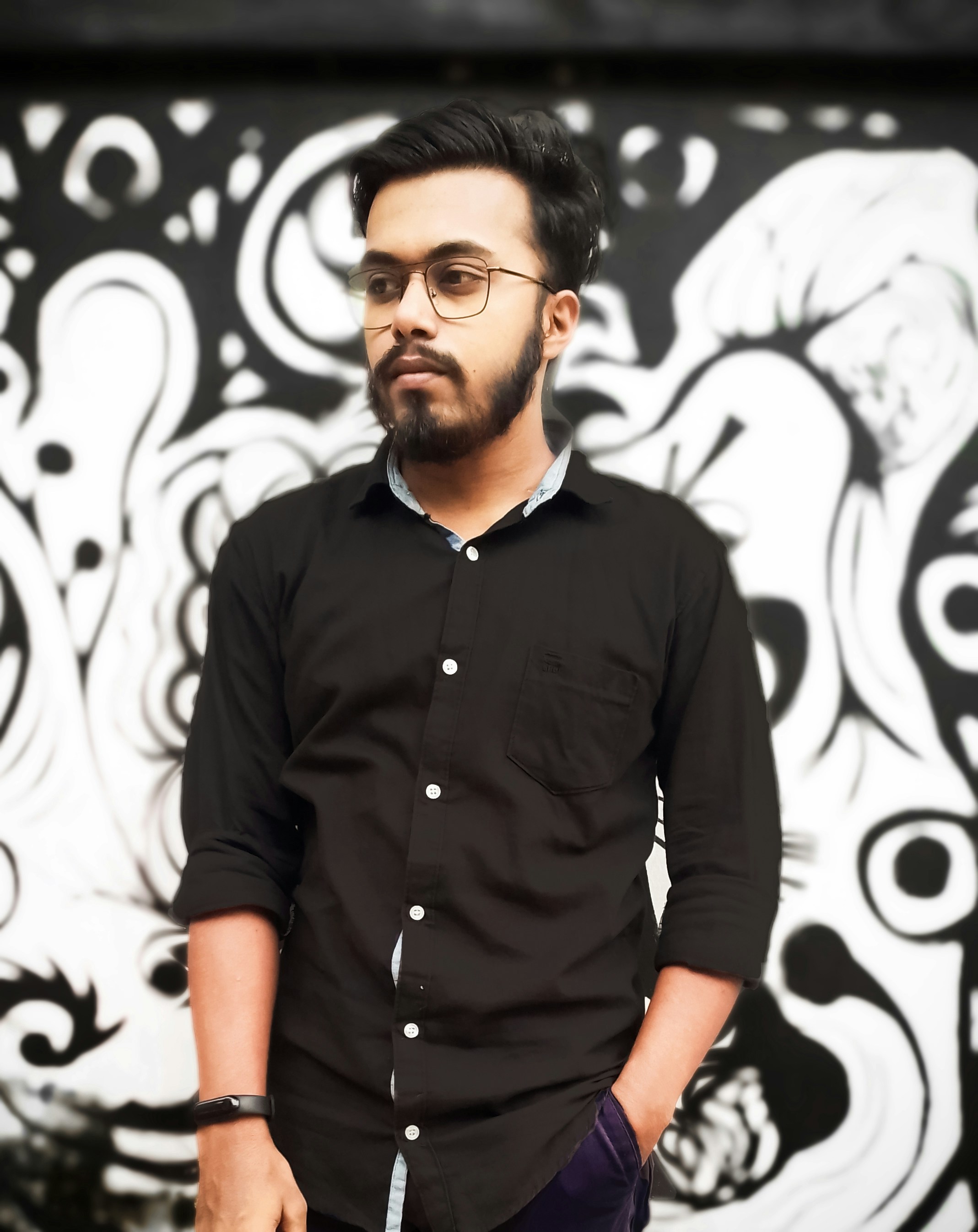 Man with glasses and beard, casual shirt, neutral background