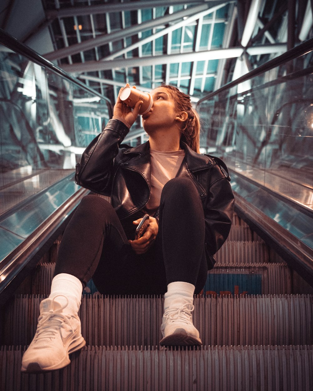 a woman sitting on a metal railing