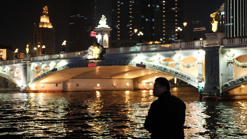 a man standing in water with a statue in the background