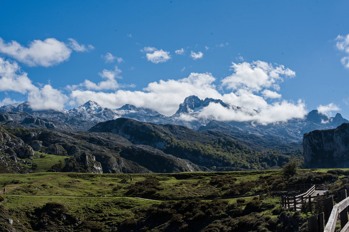 Sierras verdes bajo un cielo con nubes