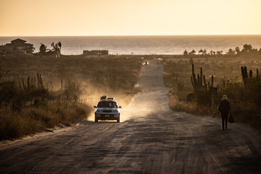 un coche conduciendo por un camino de tierra