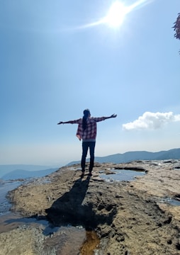a person standing on a rocky beach