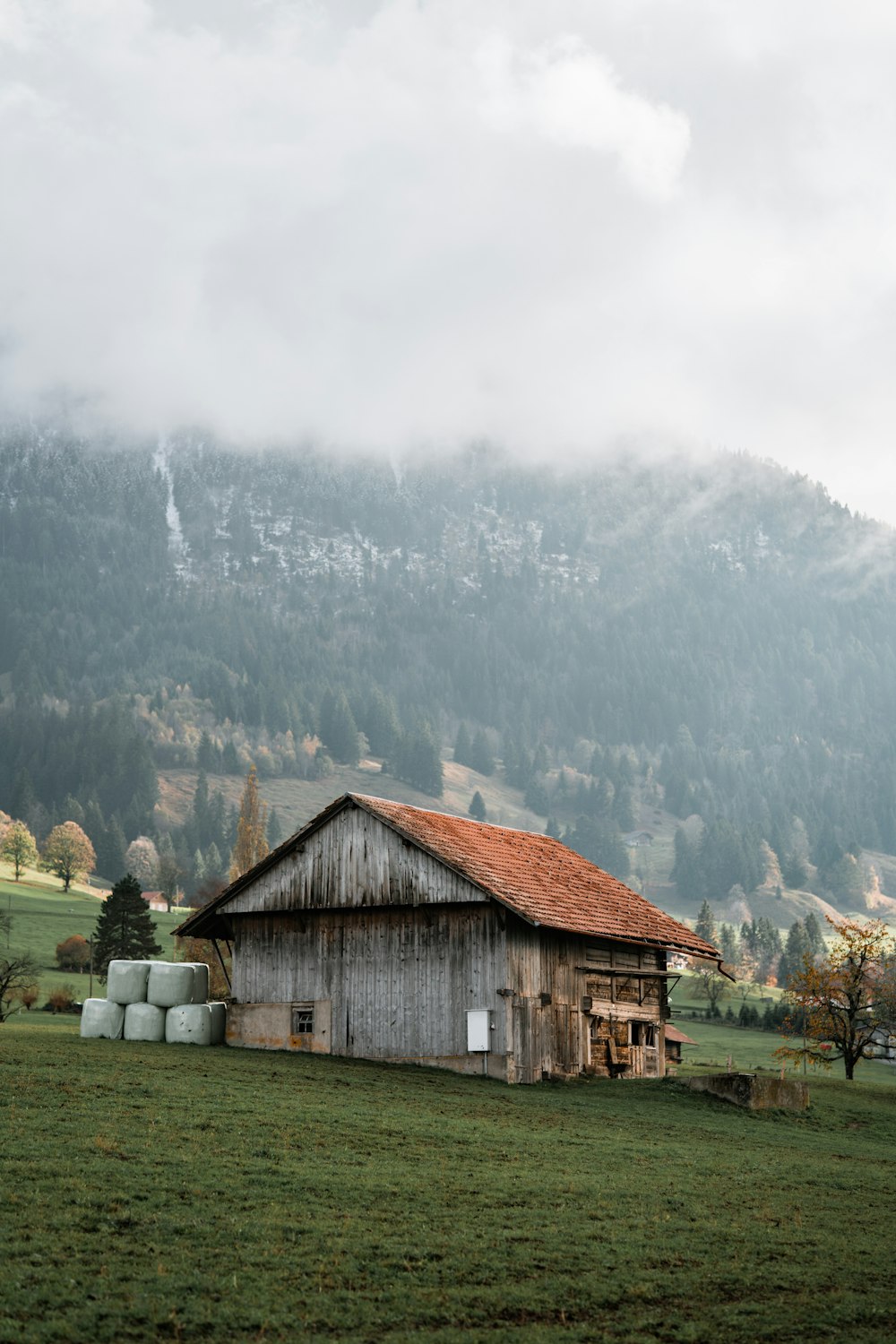 a wooden building in a grassy field