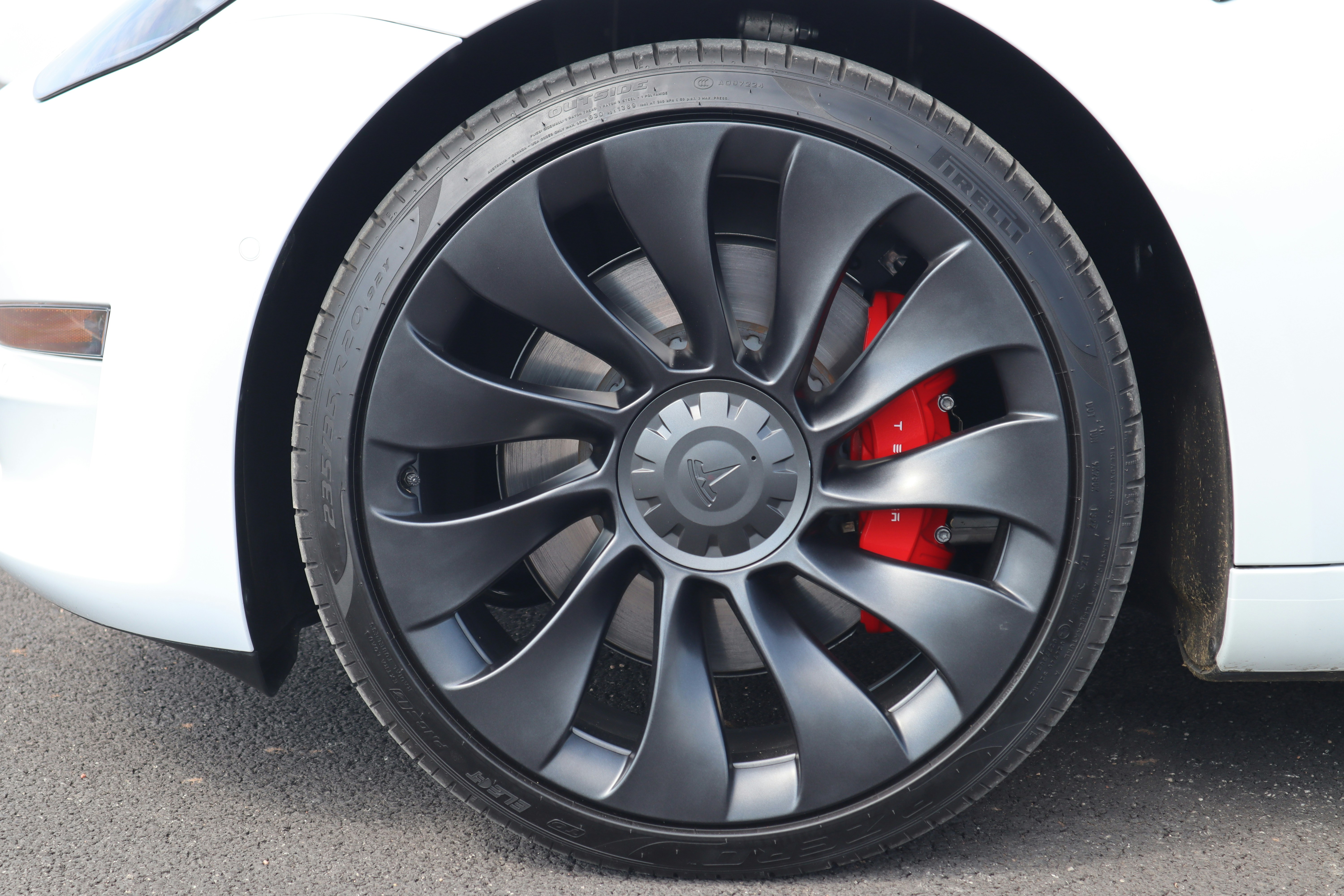 Closeup of a car tire on a wet urban road where tire wear particles can be washed into drains.