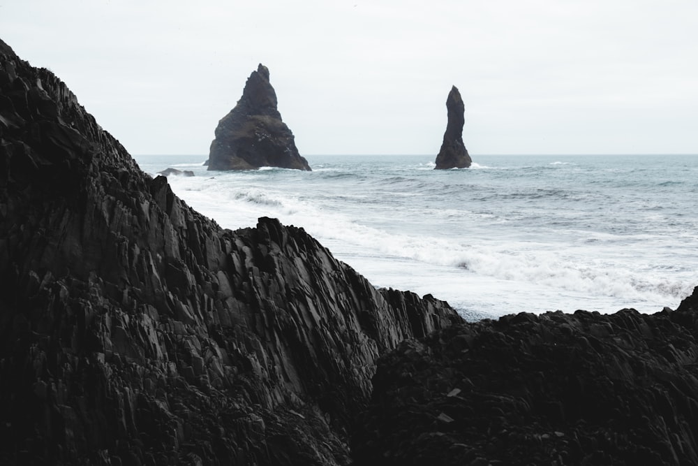 a rocky beach with a large body of water in the background