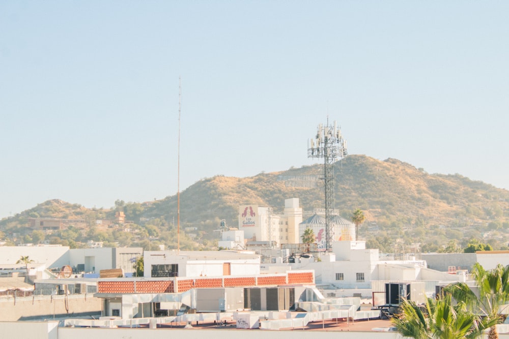 a large hill with buildings and a tower in the background