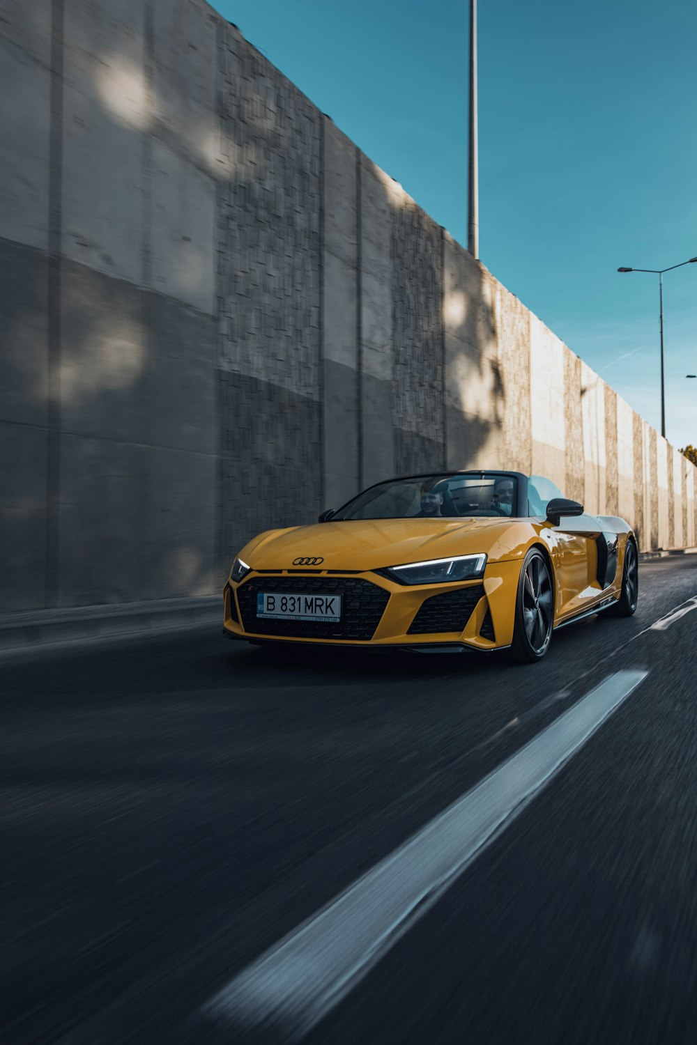 a yellow sports car on a road