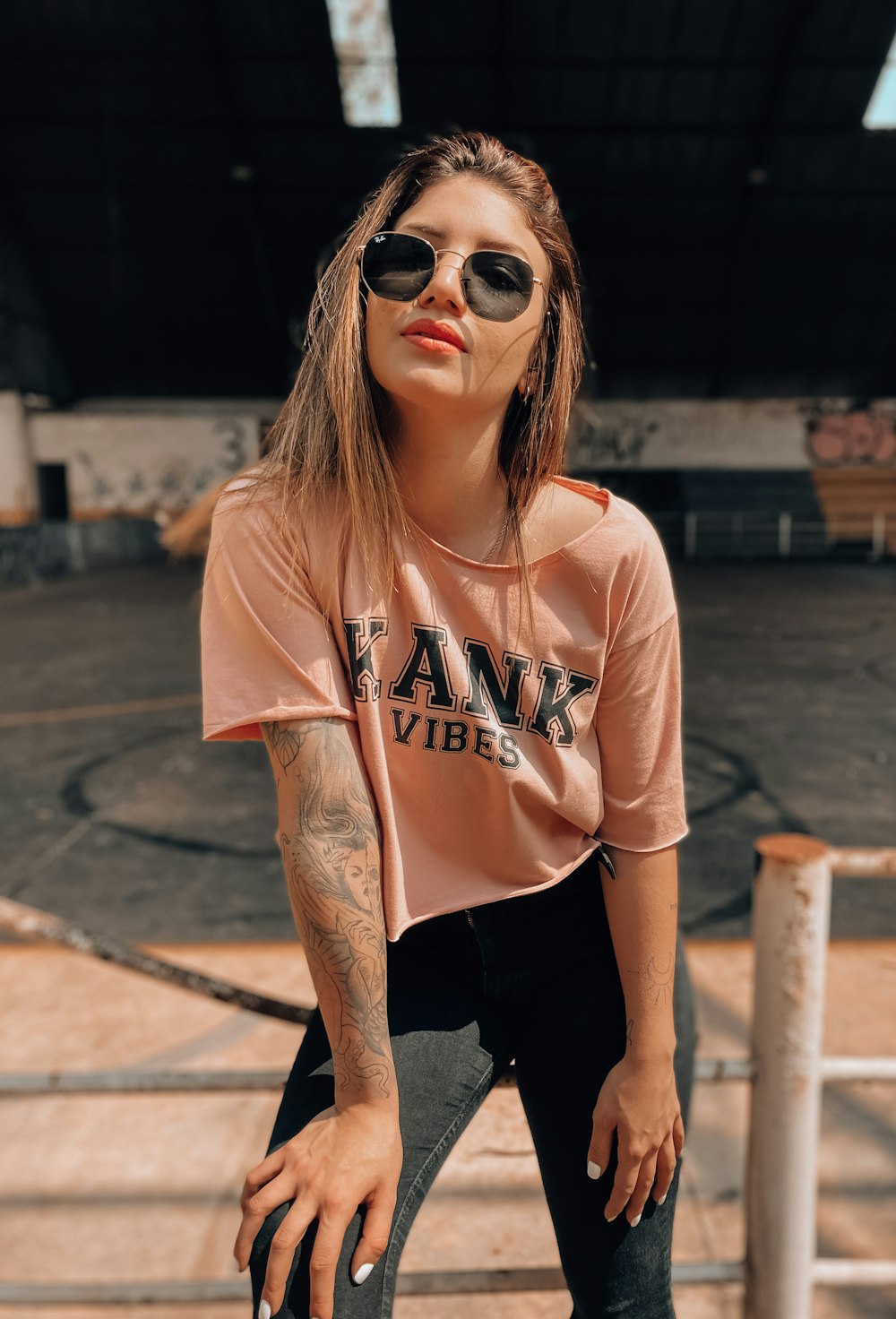 a woman wearing a pink shirt and sunglasses