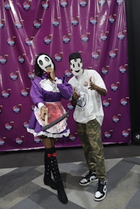Close-up of hands holding fun props like oversized glasses and feather boas at a photo booth.