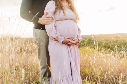a man and woman kissing in a field of tall grass