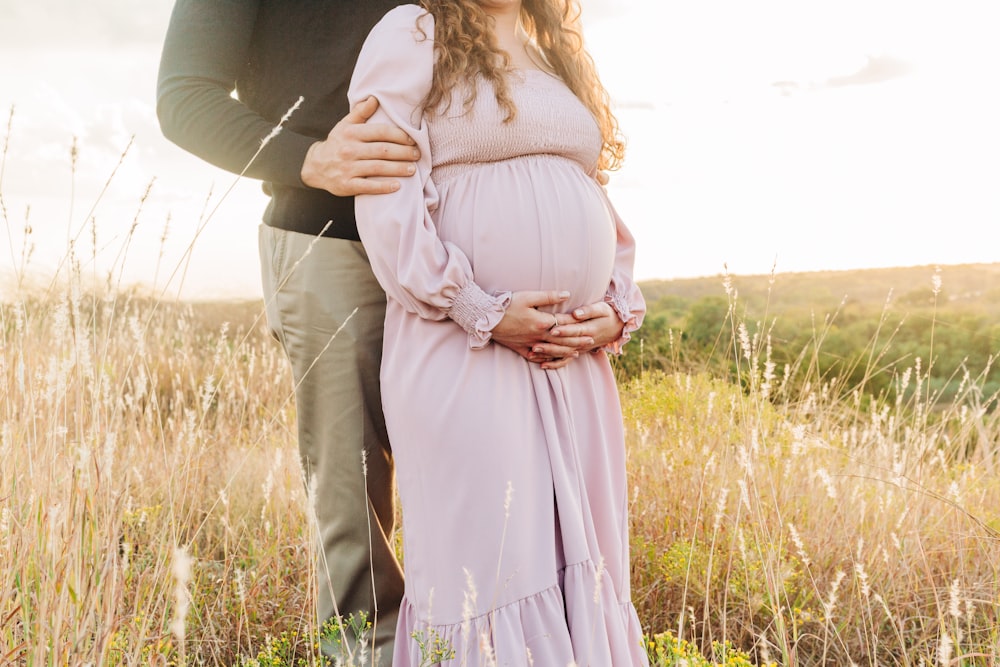 a man and woman kissing in a field of tall grass