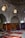 An interior scene featuring a collection of richly decorated carpets displayed against walls and laid on the floor. The room has arched ceilings with small, intricate windows allowing soft, diffused light to enter. Various carpets with ornate patterns and a range of colors are stacked and spread across a tiled floor, creating a vibrant display.