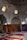 An interior scene featuring a collection of richly decorated carpets displayed against walls and laid on the floor. The room has arched ceilings with small, intricate windows allowing soft, diffused light to enter. Various carpets with ornate patterns and a range of colors are stacked and spread across a tiled floor, creating a vibrant display.