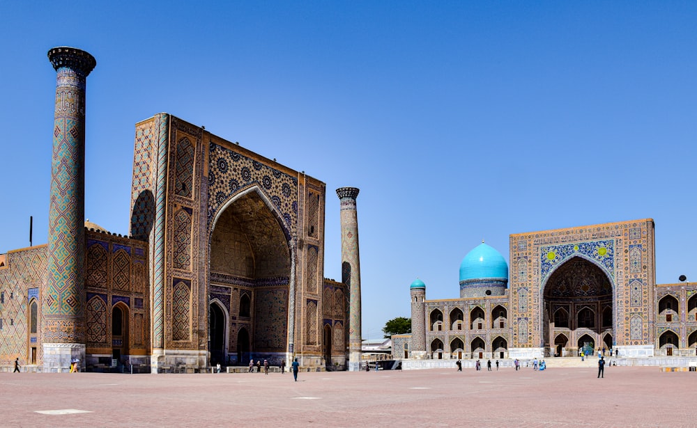 a large building with pillars with Registan in the background