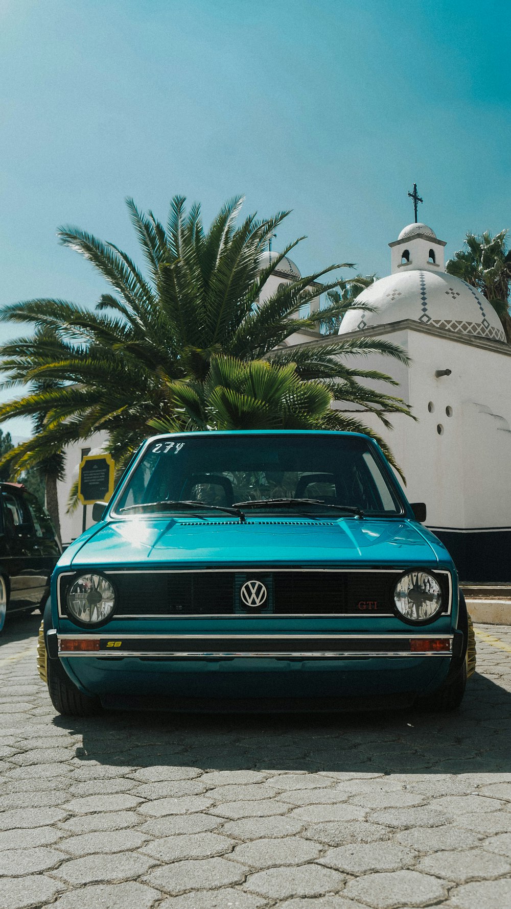 a blue car parked in front of a white building