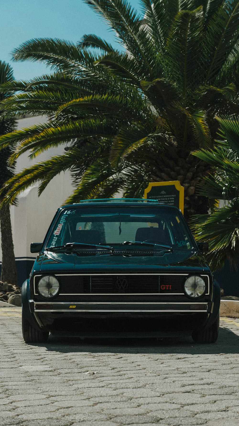 a car parked under a palm tree