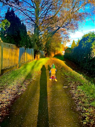 A child riding a bike with a big smile on a sunny day.