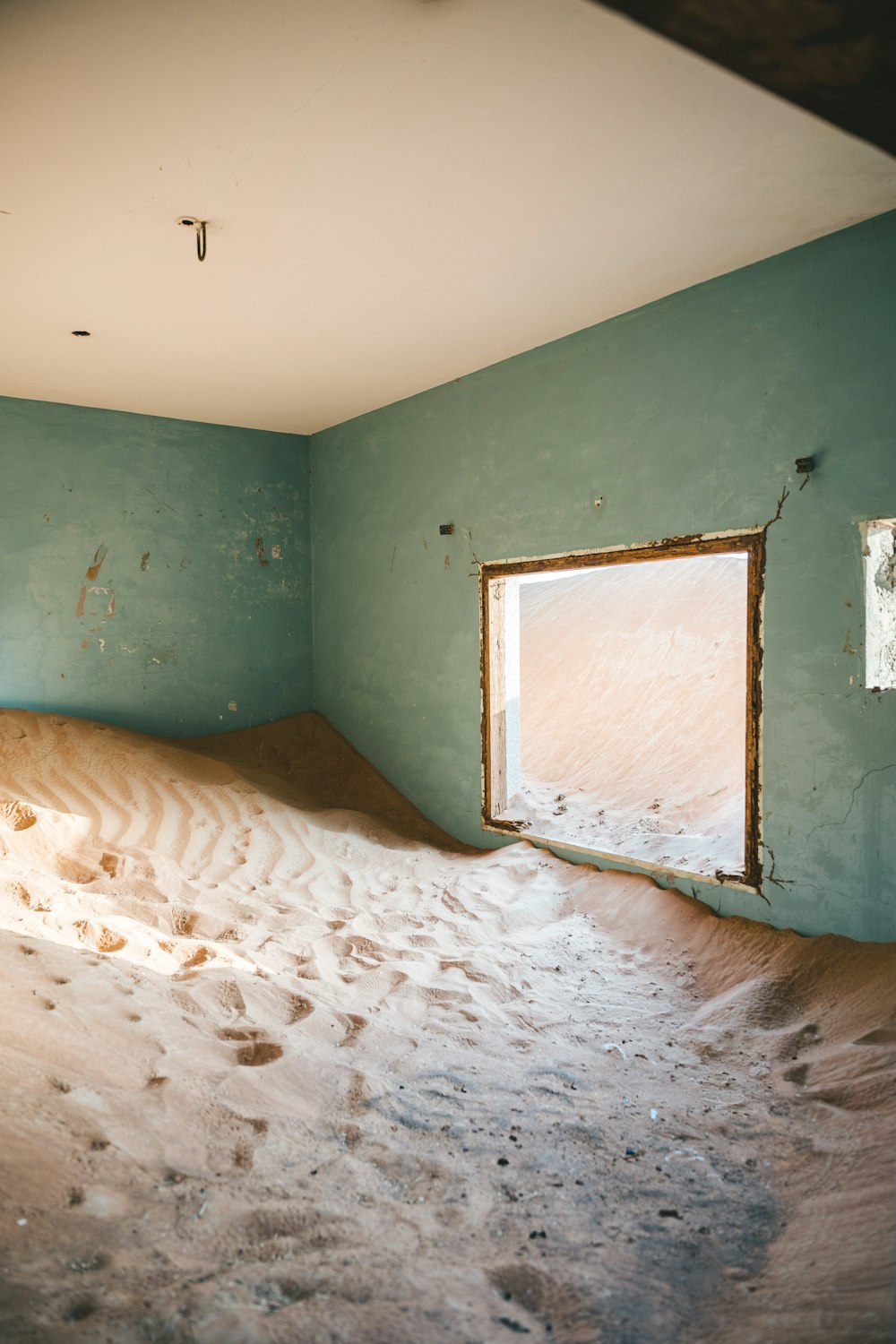 a room with a window and a wall with a painting on it