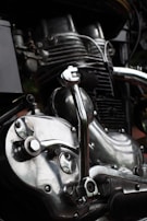 Close-up of a polished motorcycle engine reflecting the workshop lights.