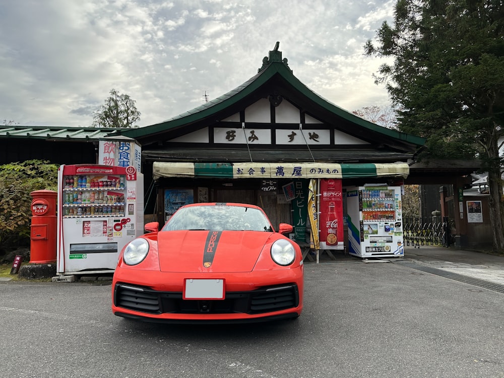 a red sports car parked in front of a gas station