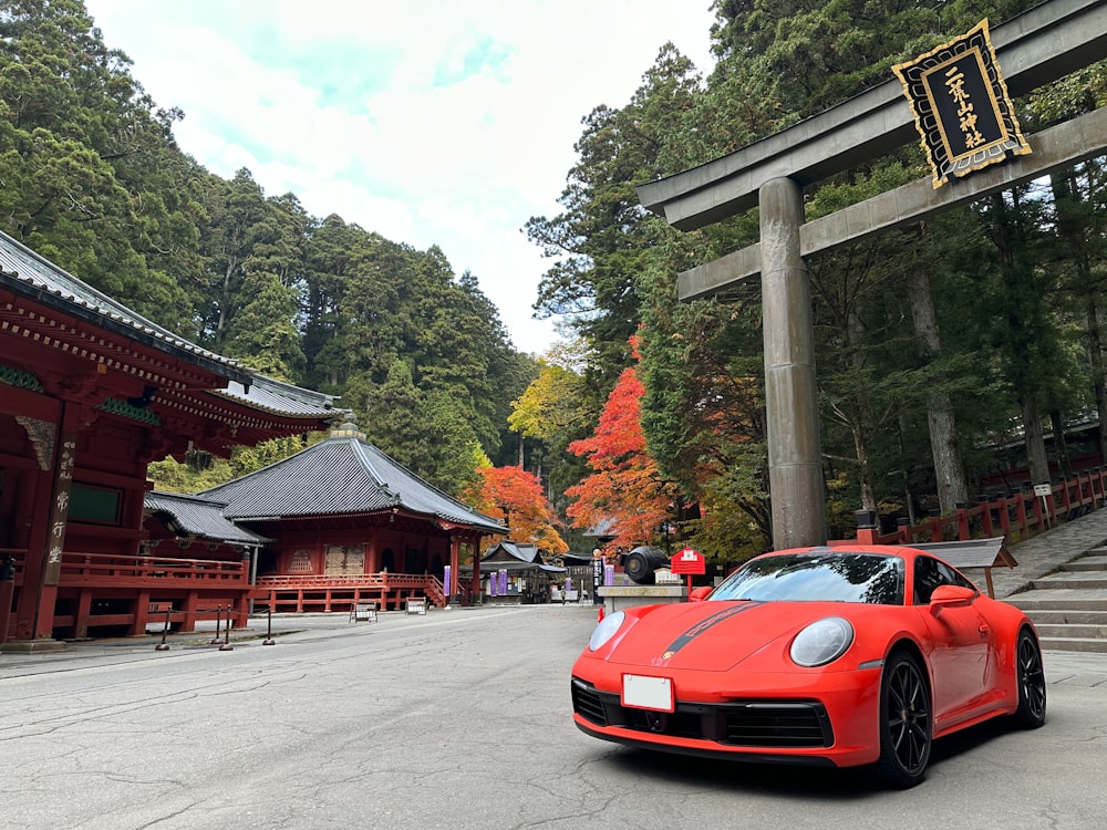 a red sports car parked in front of a building with a sign