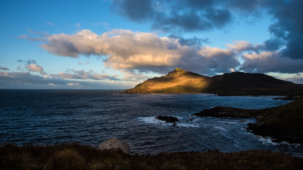 a body of water with hills in the background