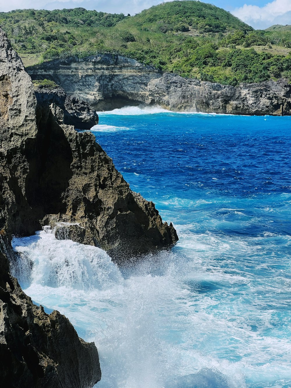 a rocky cliff with a body of water below