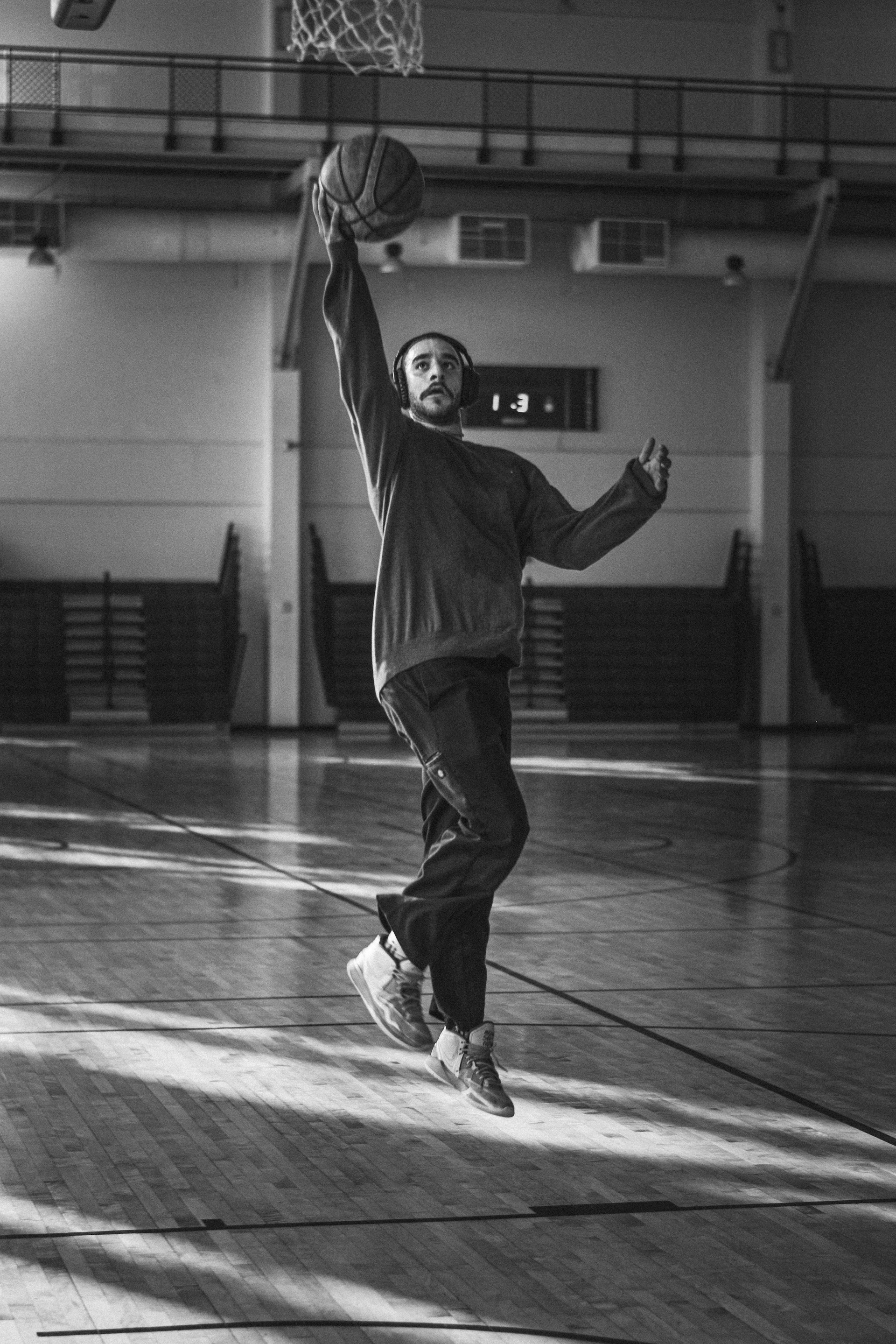 A thrilling moment capturing a player mid-air going for a layup during a youth basketball match.