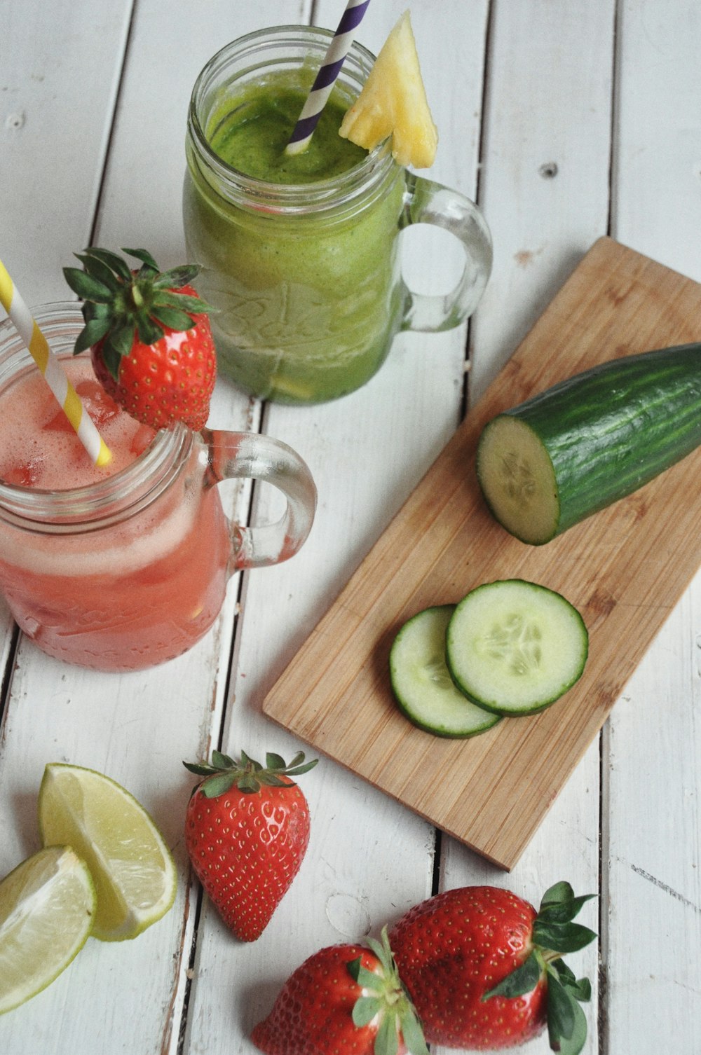 a cutting board with fruit and a glass of juice