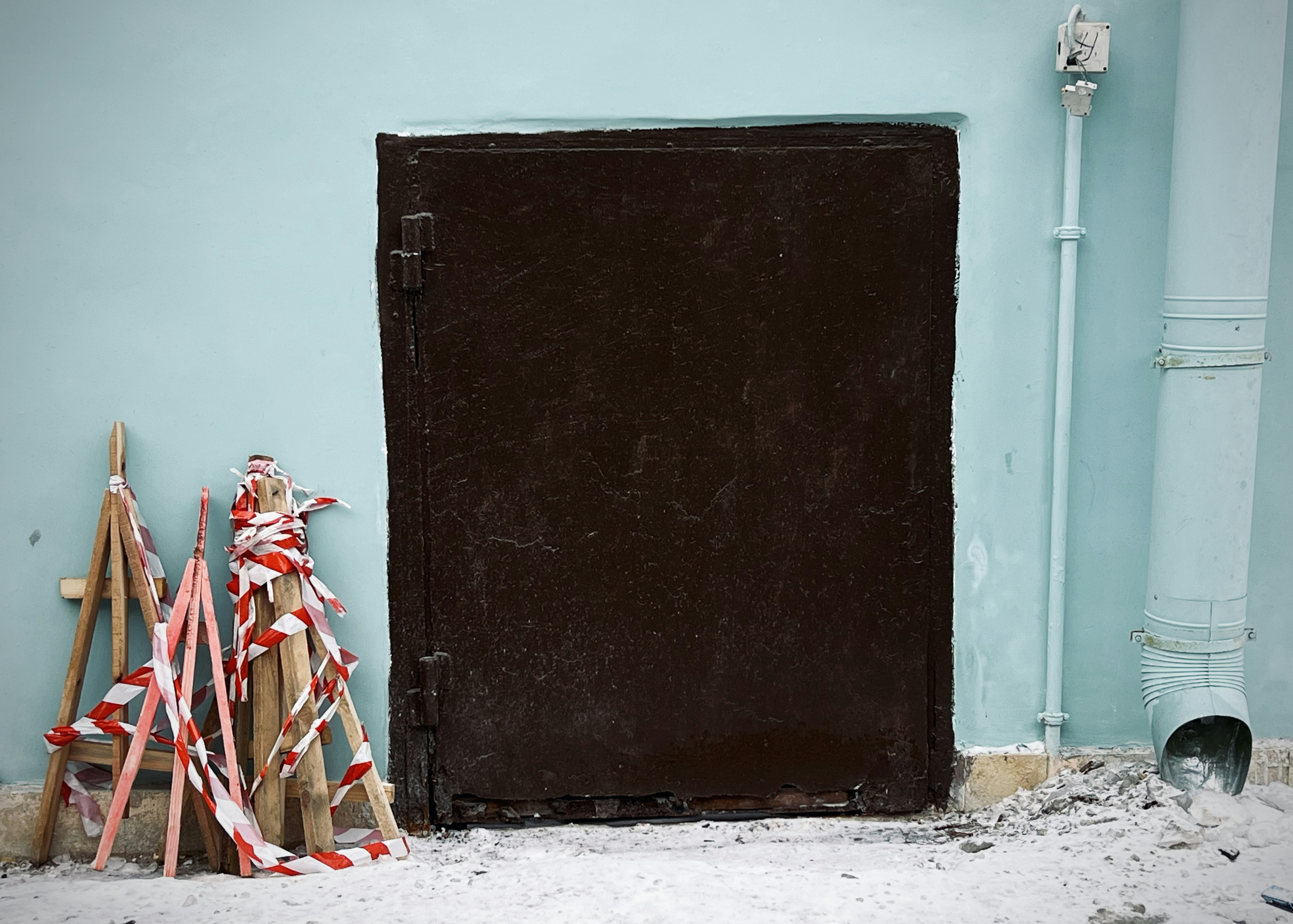 a black door with a metal frame and a red chair in front of it