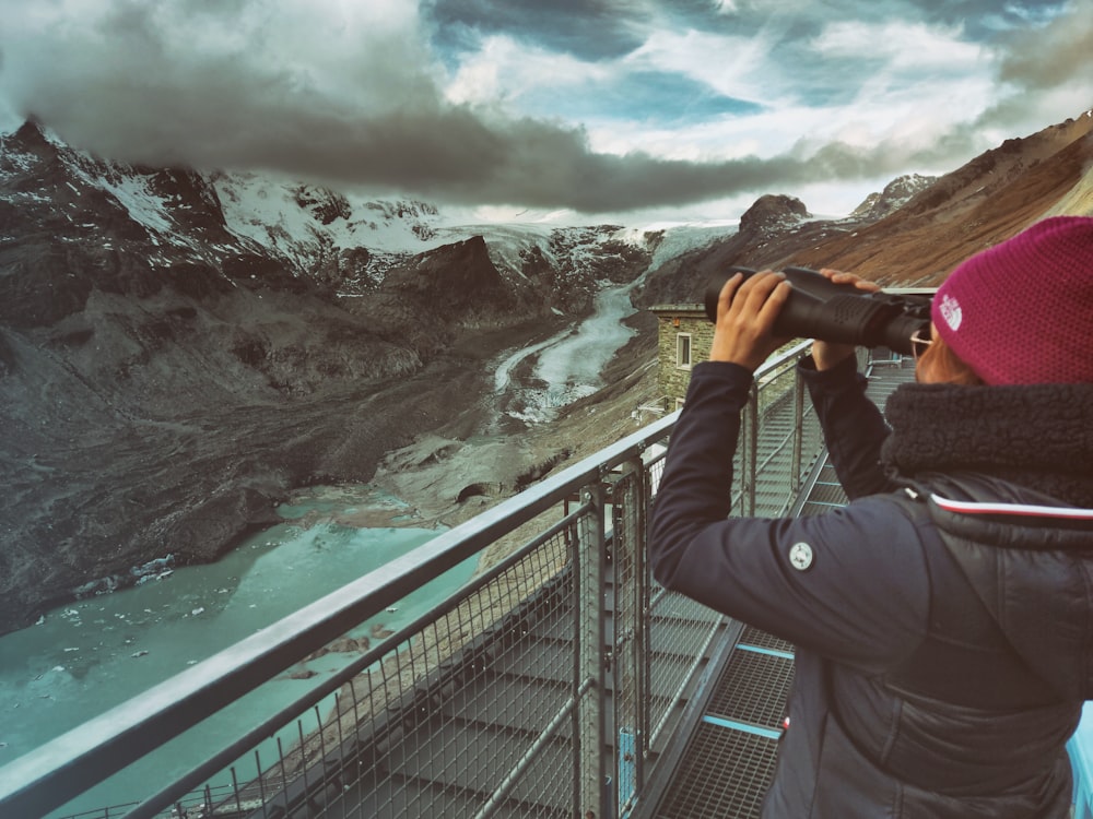 a person taking a picture of a waterfall