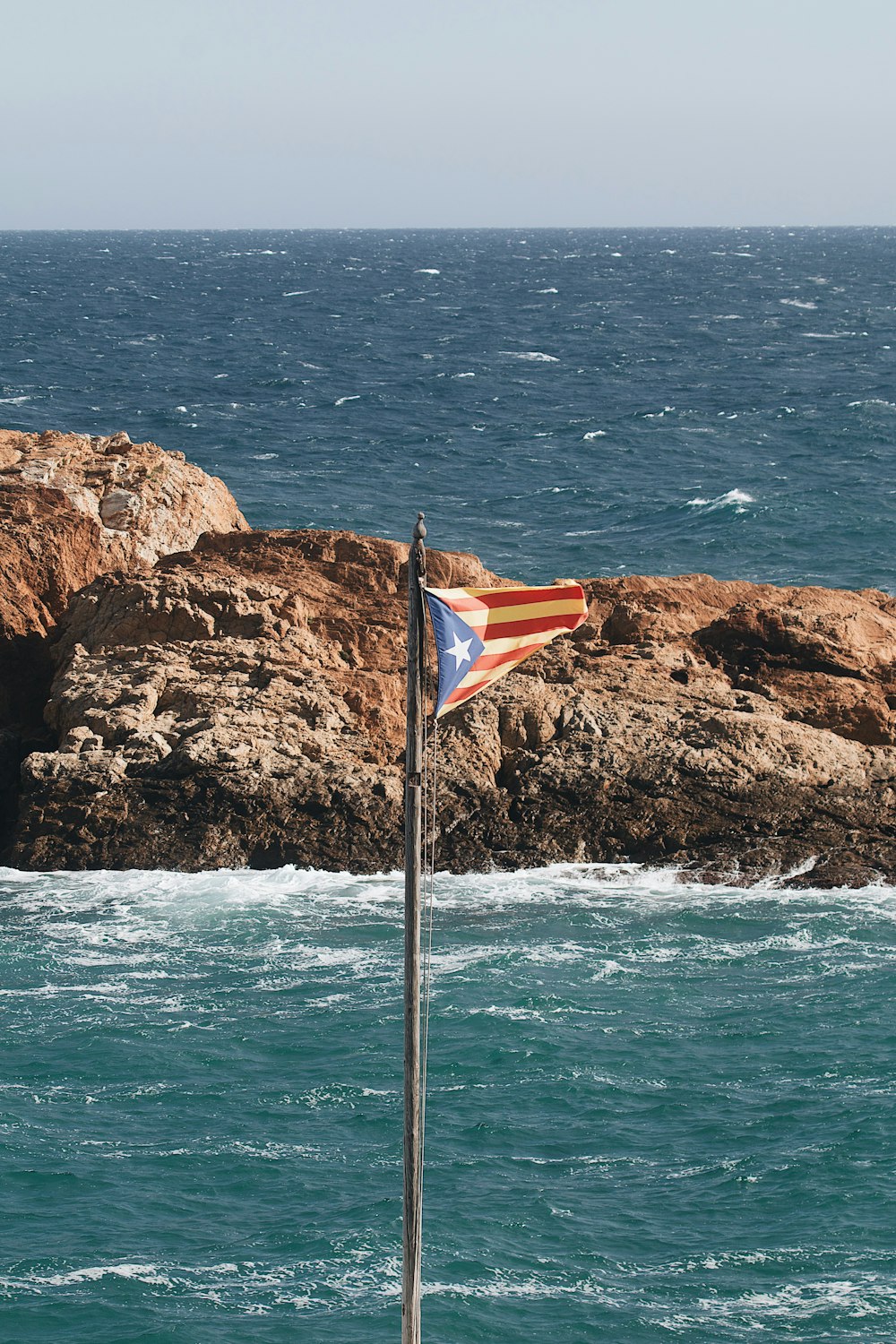 una bandera en un poste en el agua