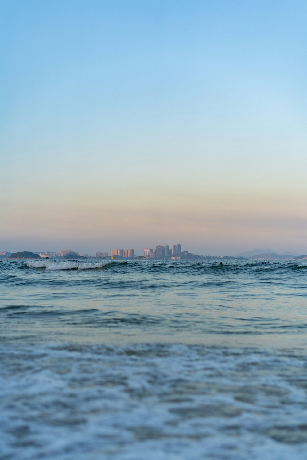 a body of water with a city in the distance