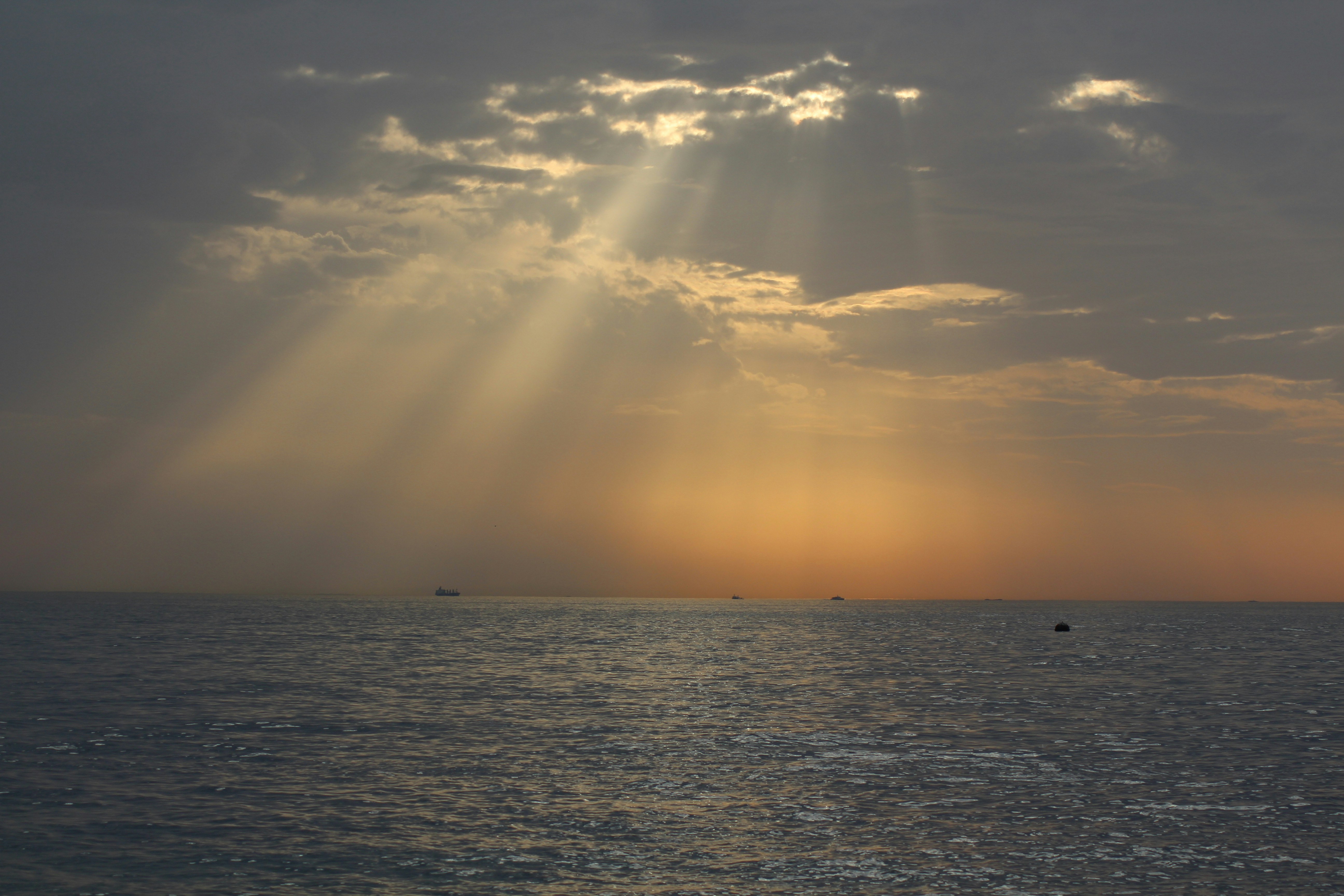 a body of water with a cloudy sky above it