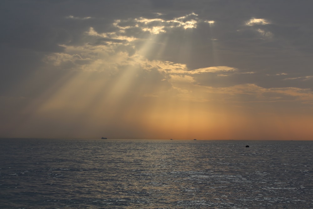 a body of water with a cloudy sky above it