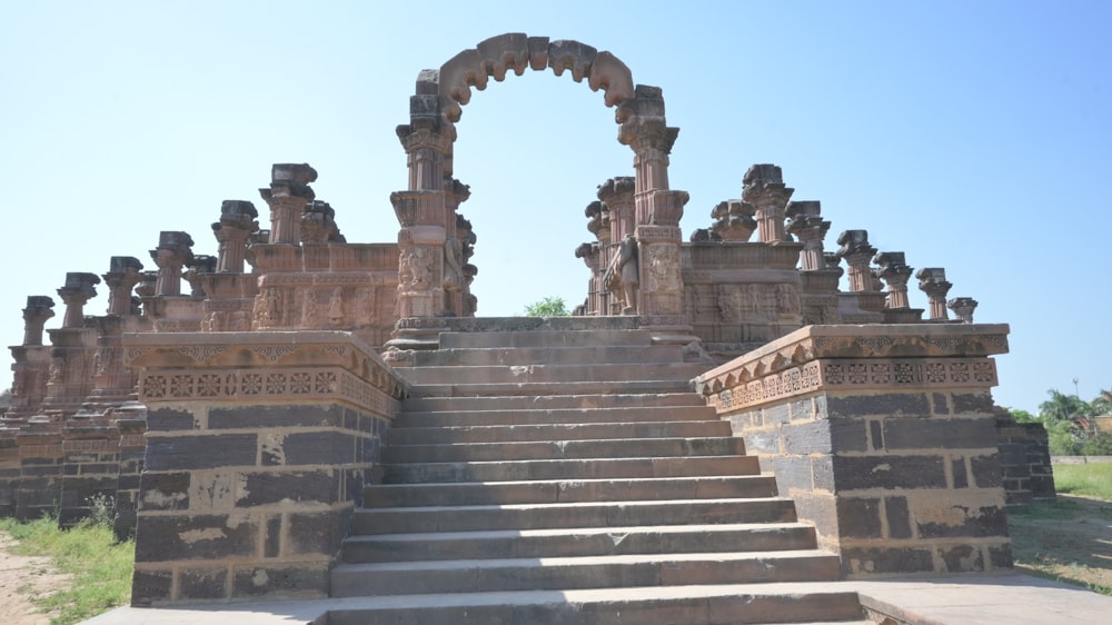 a stone staircase leading up to a building with pillars