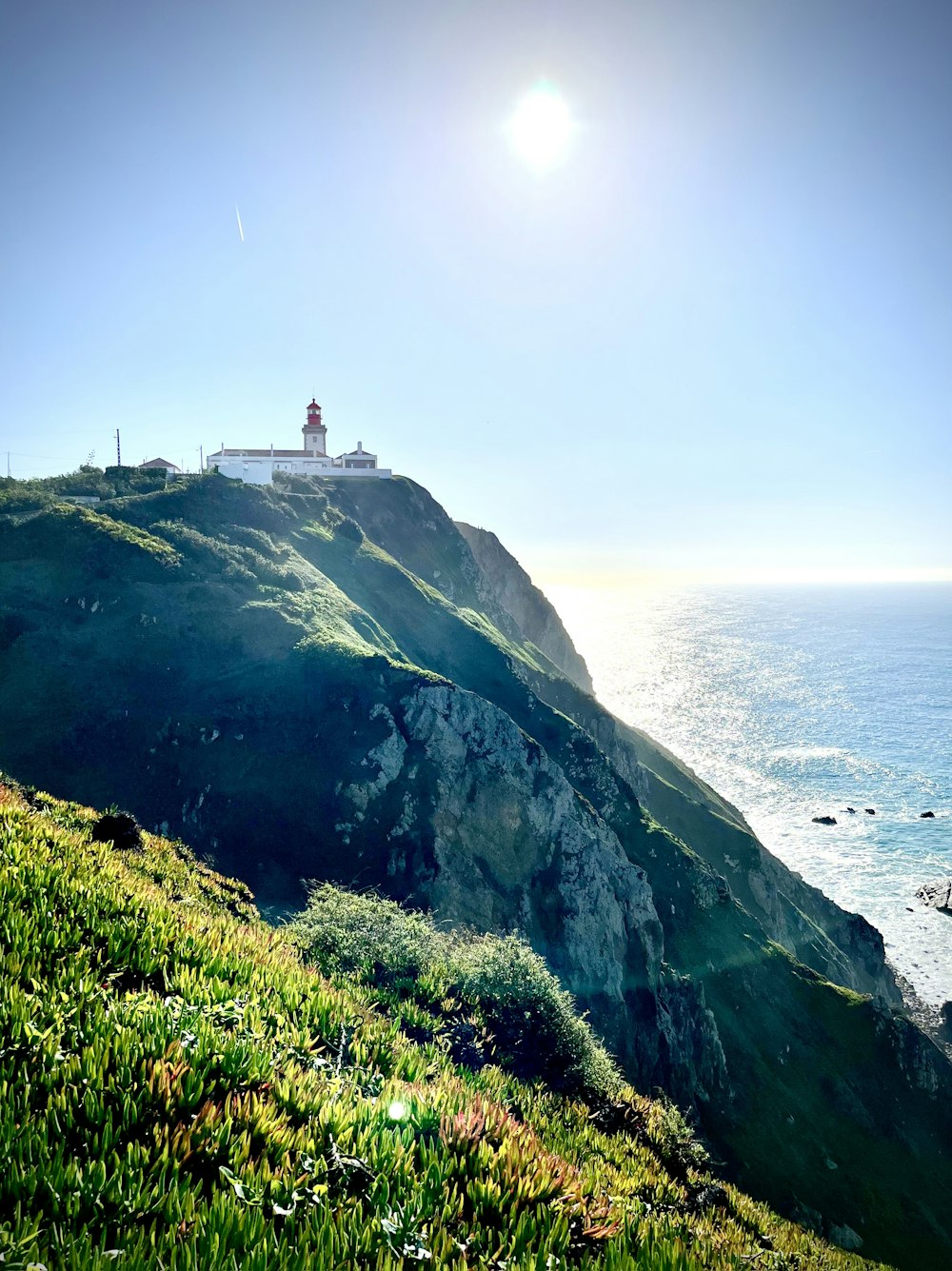 a lighthouse on a cliff by the ocean