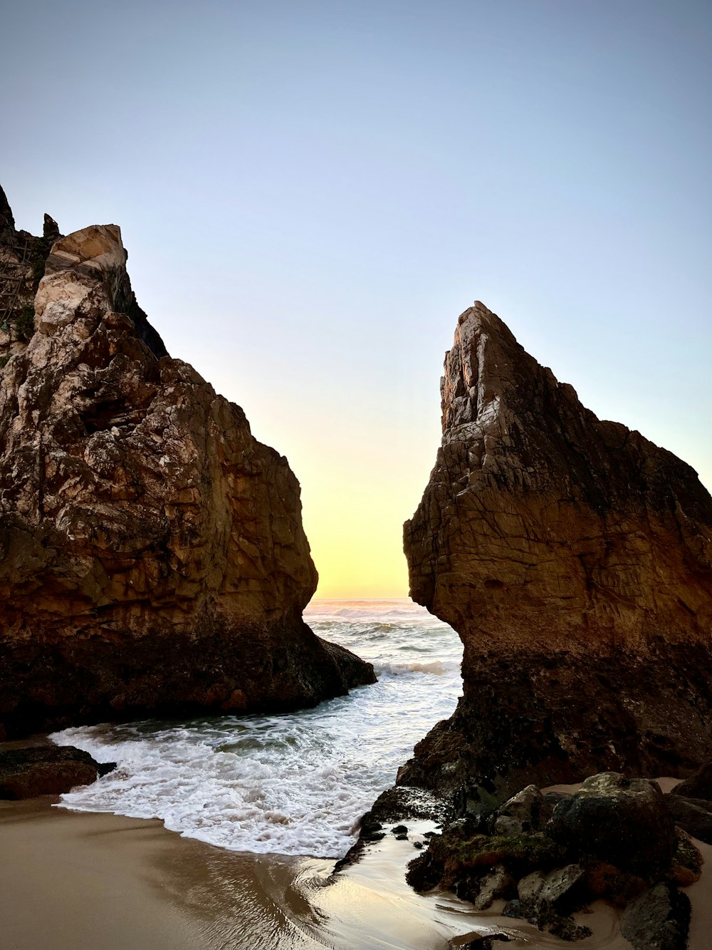 a rocky beach with a large body of water in the background