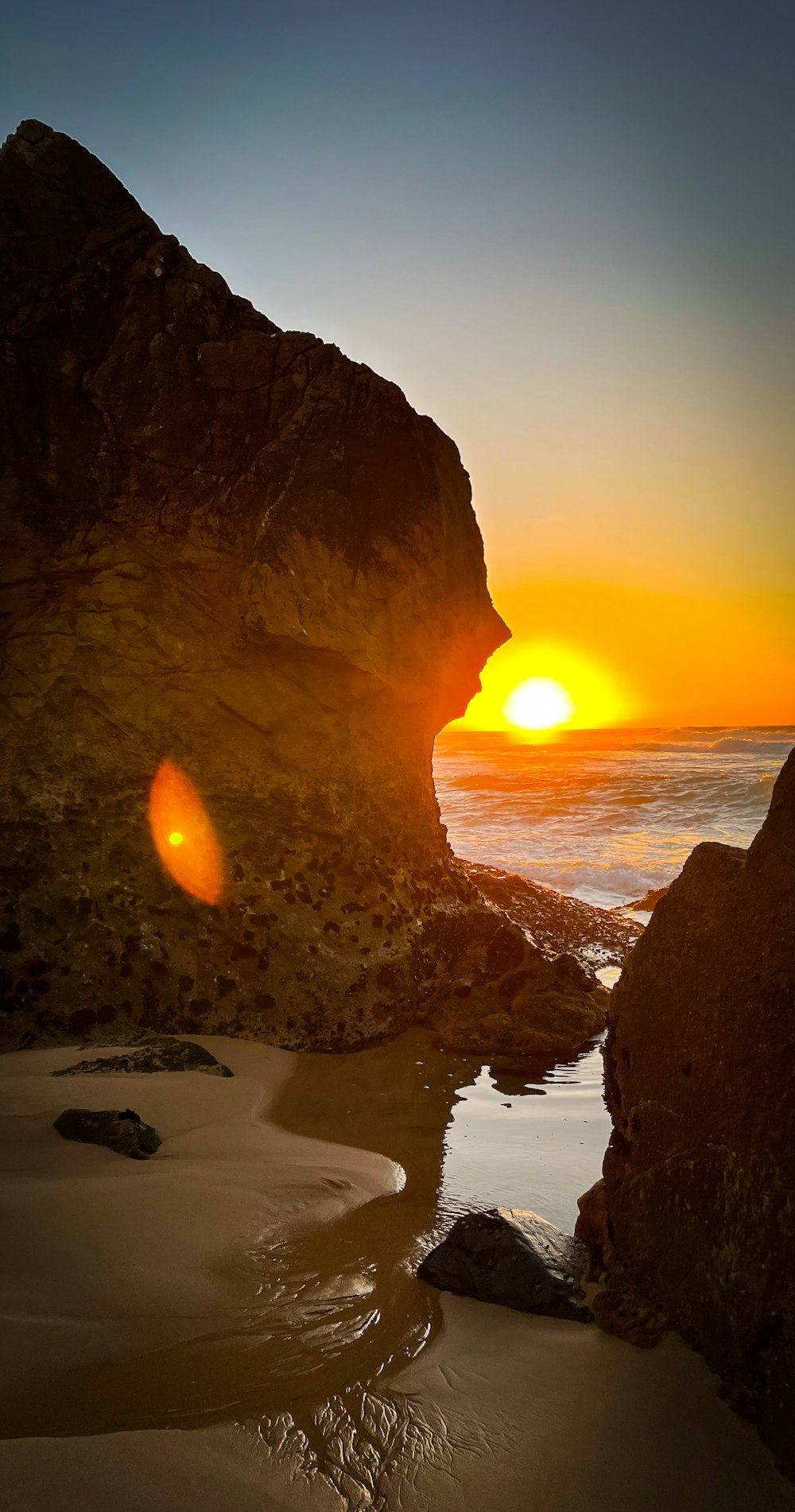 a sunset over a rocky beach