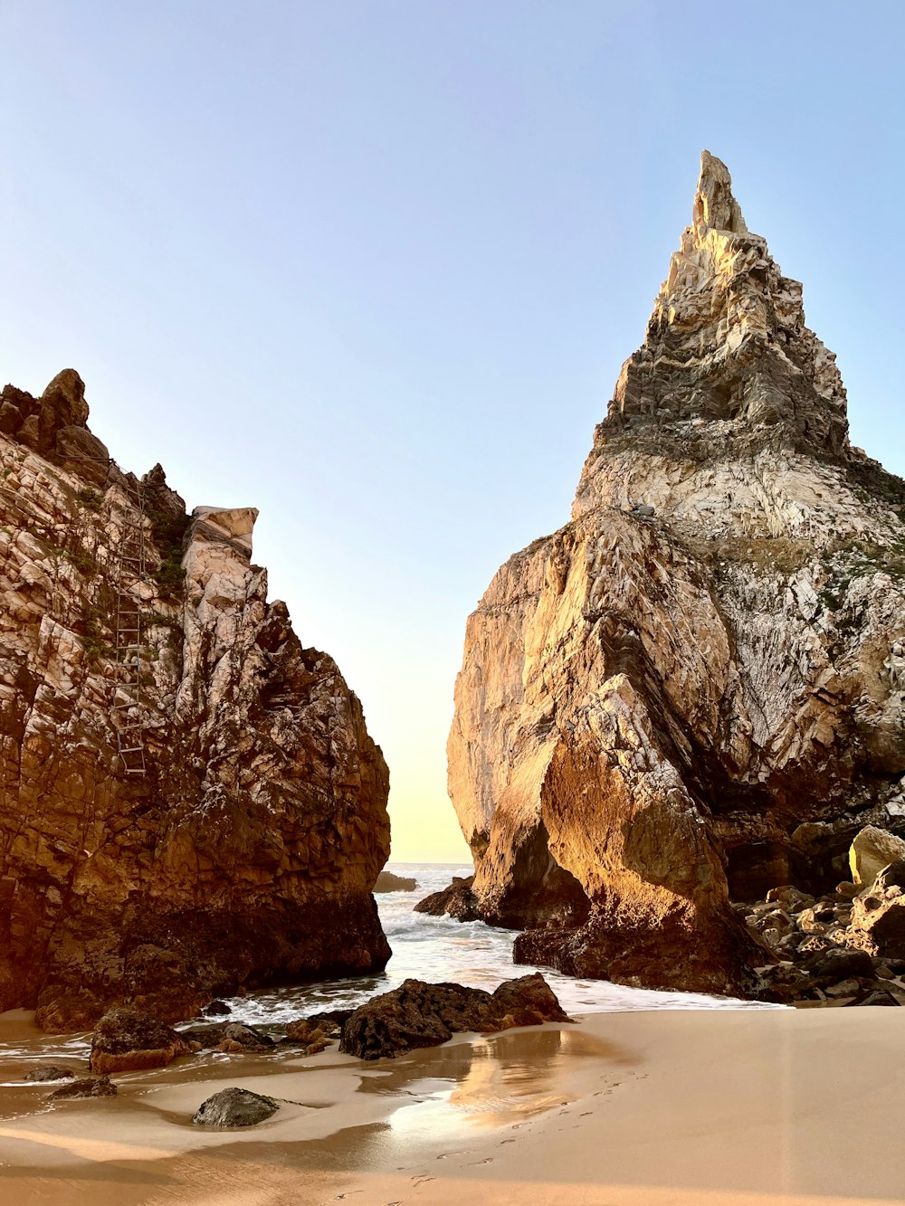 une plage rocheuse avec une grande formation rocheuse en arrière-plan